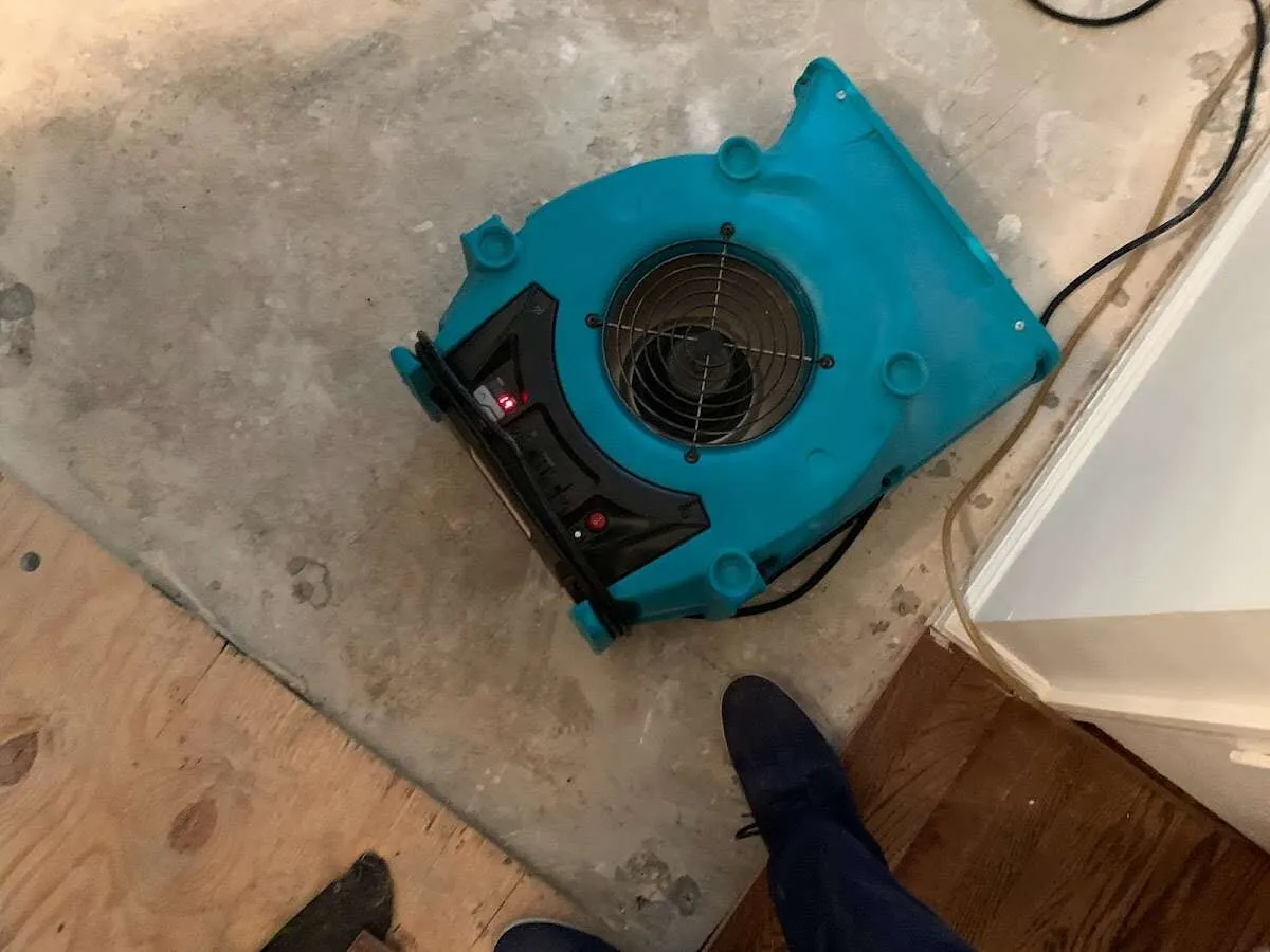 Air mover drying subfloor during Commercial Water Damage Restoration in Lawrence